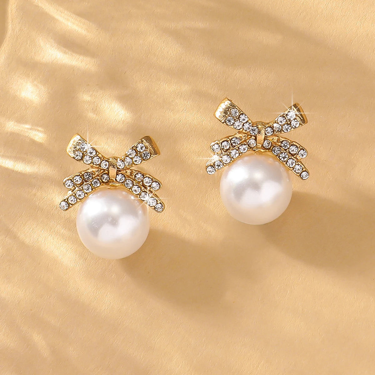 A beautiful silver bow studded with diamond pearl earrings,