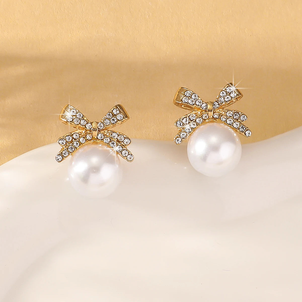 A beautiful silver bow studded with diamond pearl earrings,