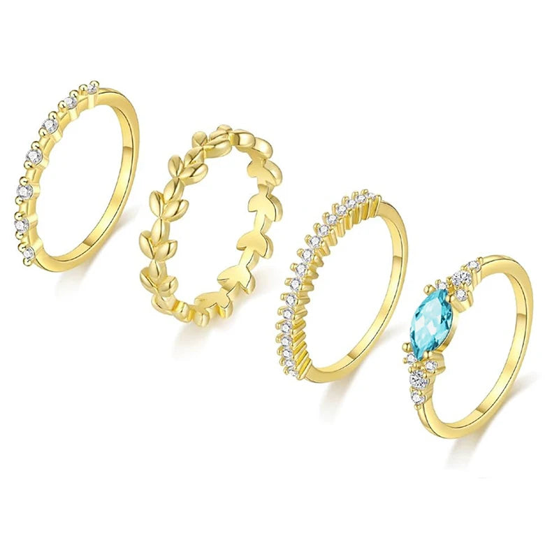 Set of 4 gold rings, with blue zirconia stone.