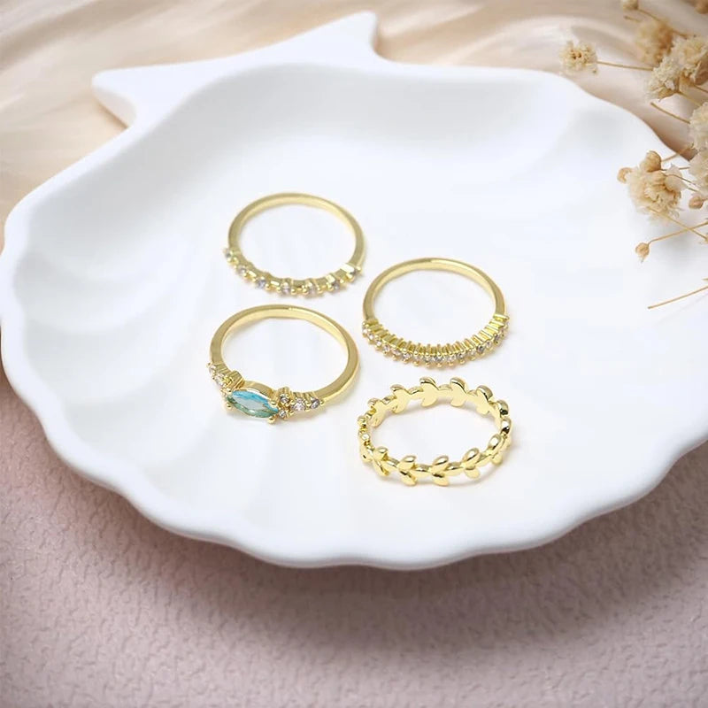 Set of 4 gold rings, with blue zirconia stone.