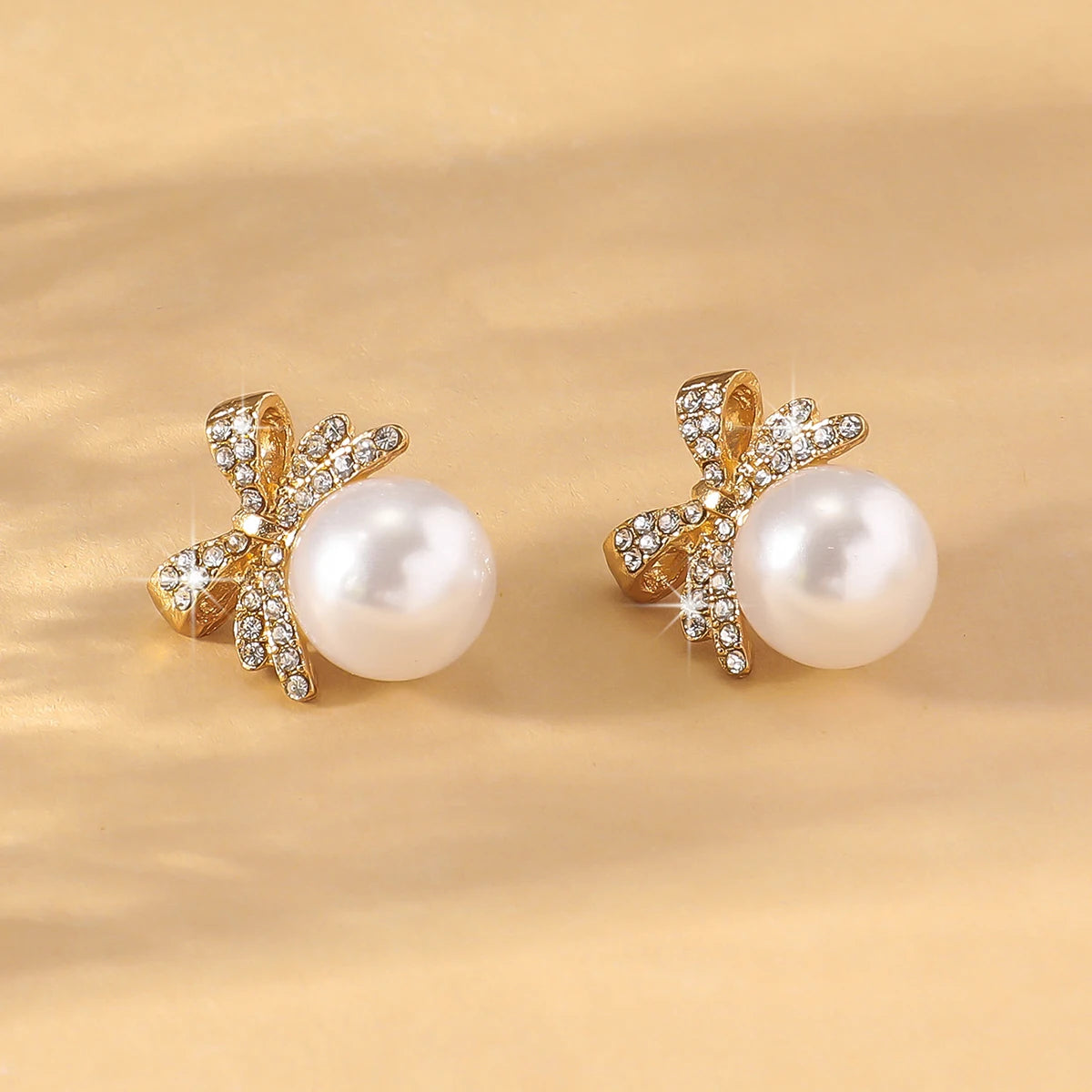 A beautiful silver bow studded with diamond pearl earrings,