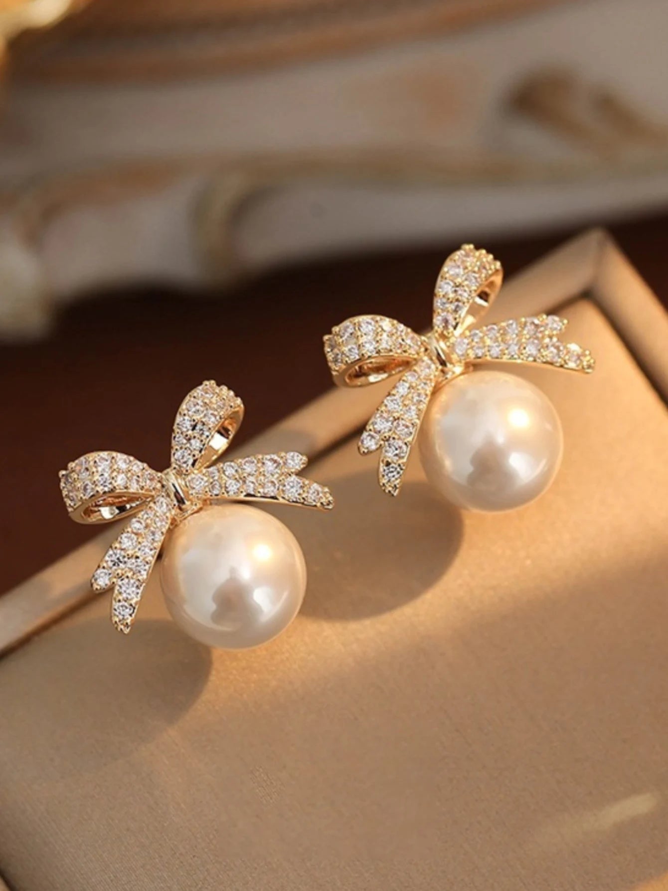 A beautiful silver bow studded with diamond pearl earrings,